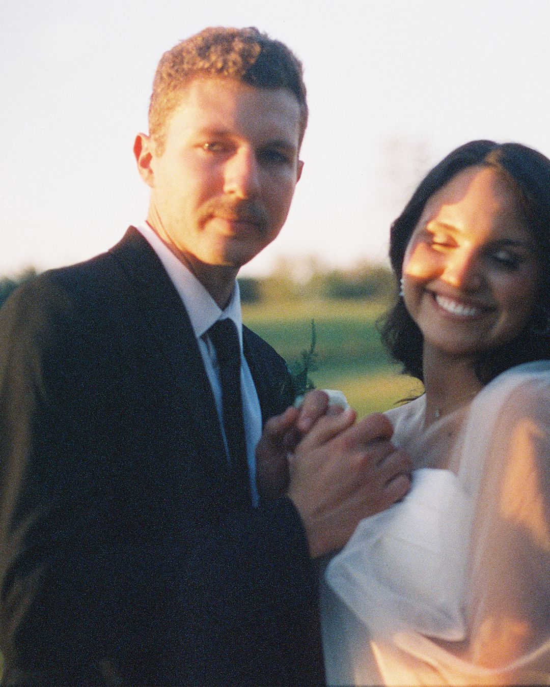 Intimate sunset portrait of newlyweds sharing a tender moment.