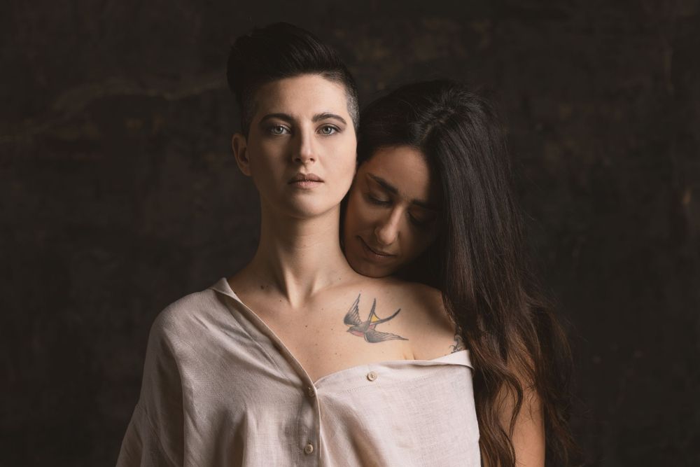 Intimate portrait series featuring two people in neutral tones against dark background.