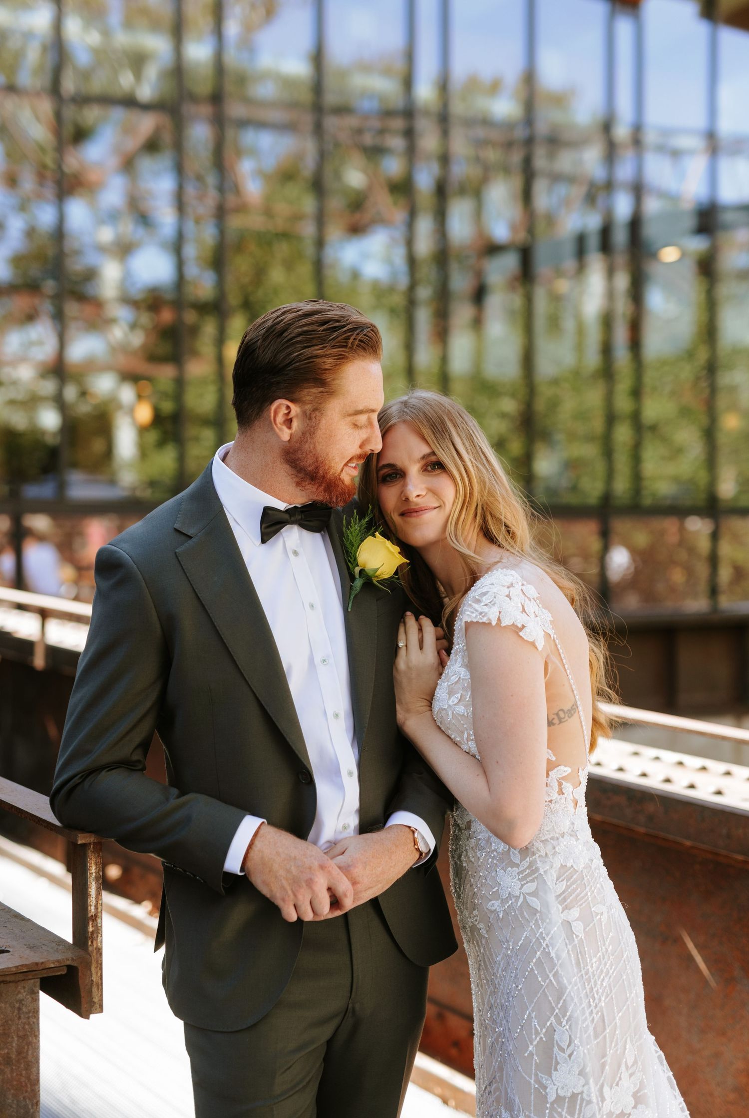 Romantic rooftop moment at Lark in Philadelphia as the groom kisses his bride’s forehead in golden sunlight.