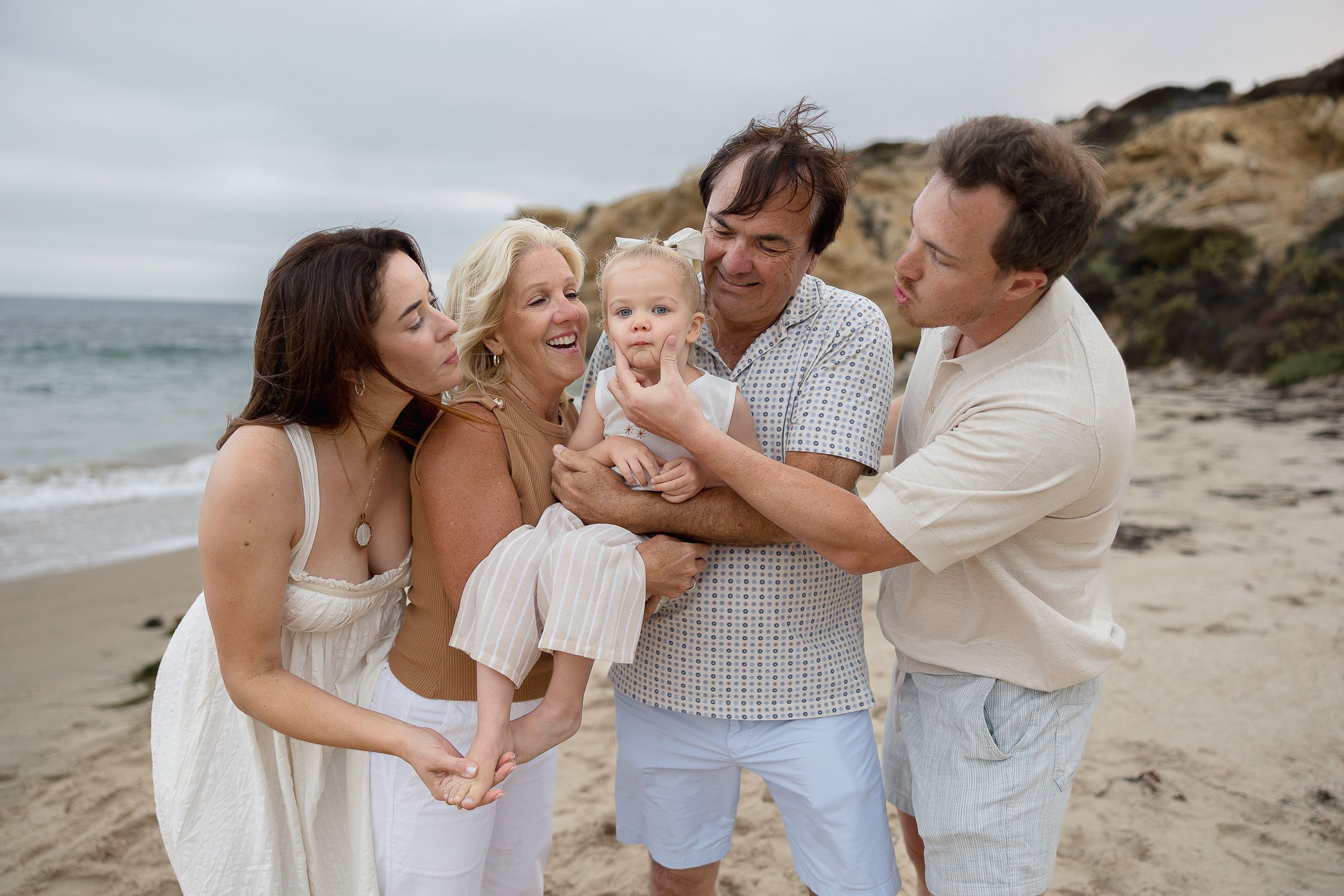 Candid beach photos of grandparents hugging granddaughter at Crystal Cove