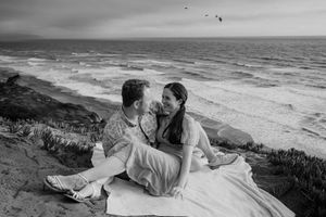 A series of black and white photos showing a romantic couple laying on a beach cliff overlooking the ocean.