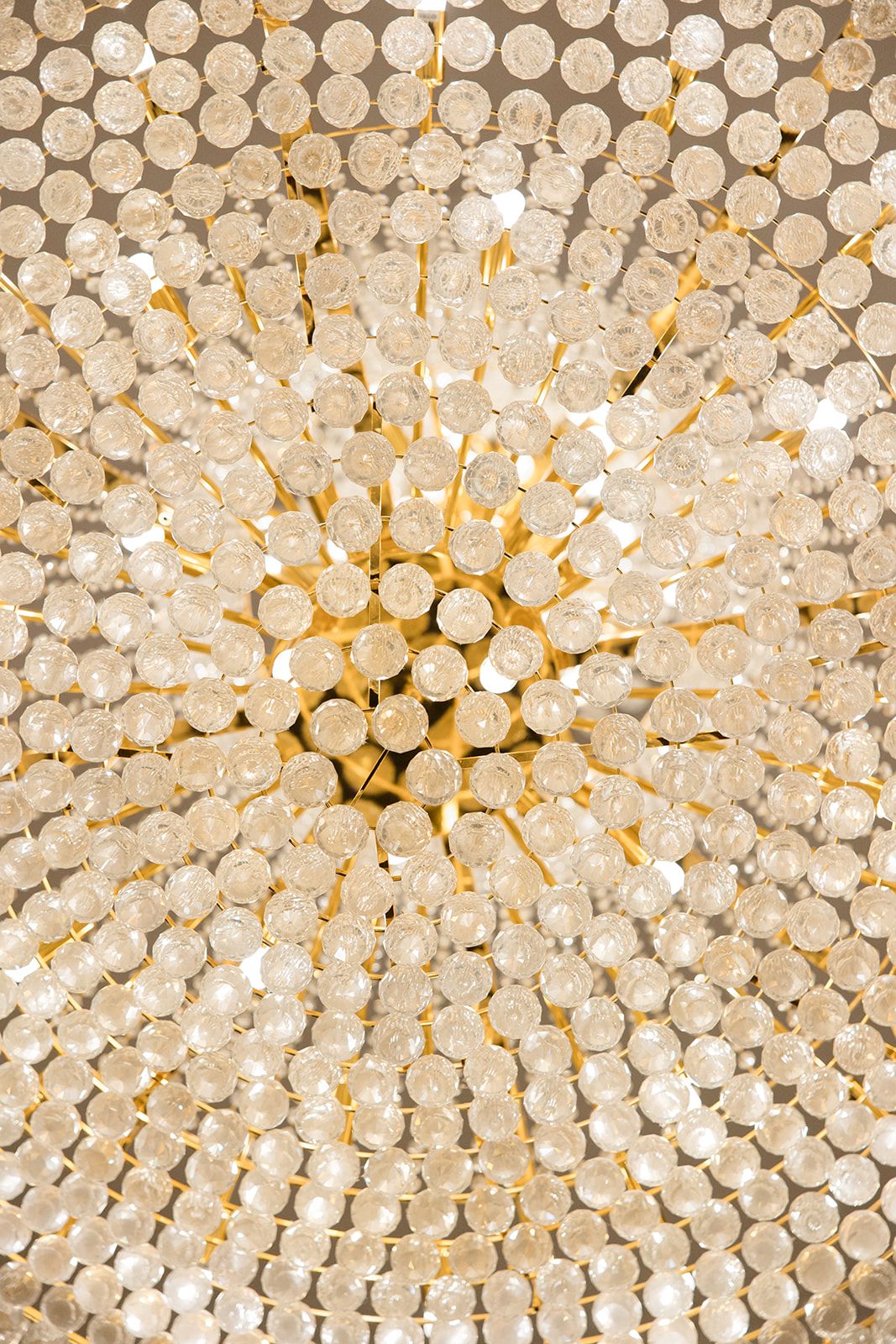 Close-up view of a circular crystal chandelier with rows of glass beads creating an elegant lighting pattern.