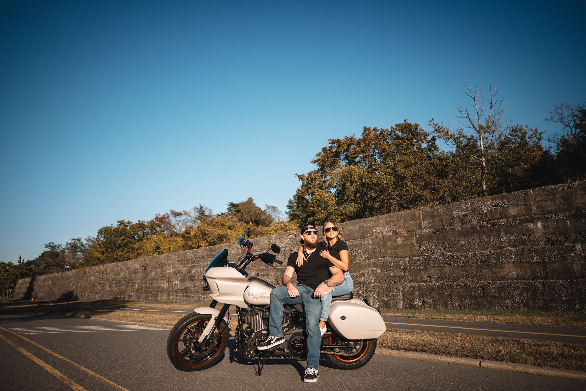 Motorcycles parked along scenic mountain road against blue sky backdrop.