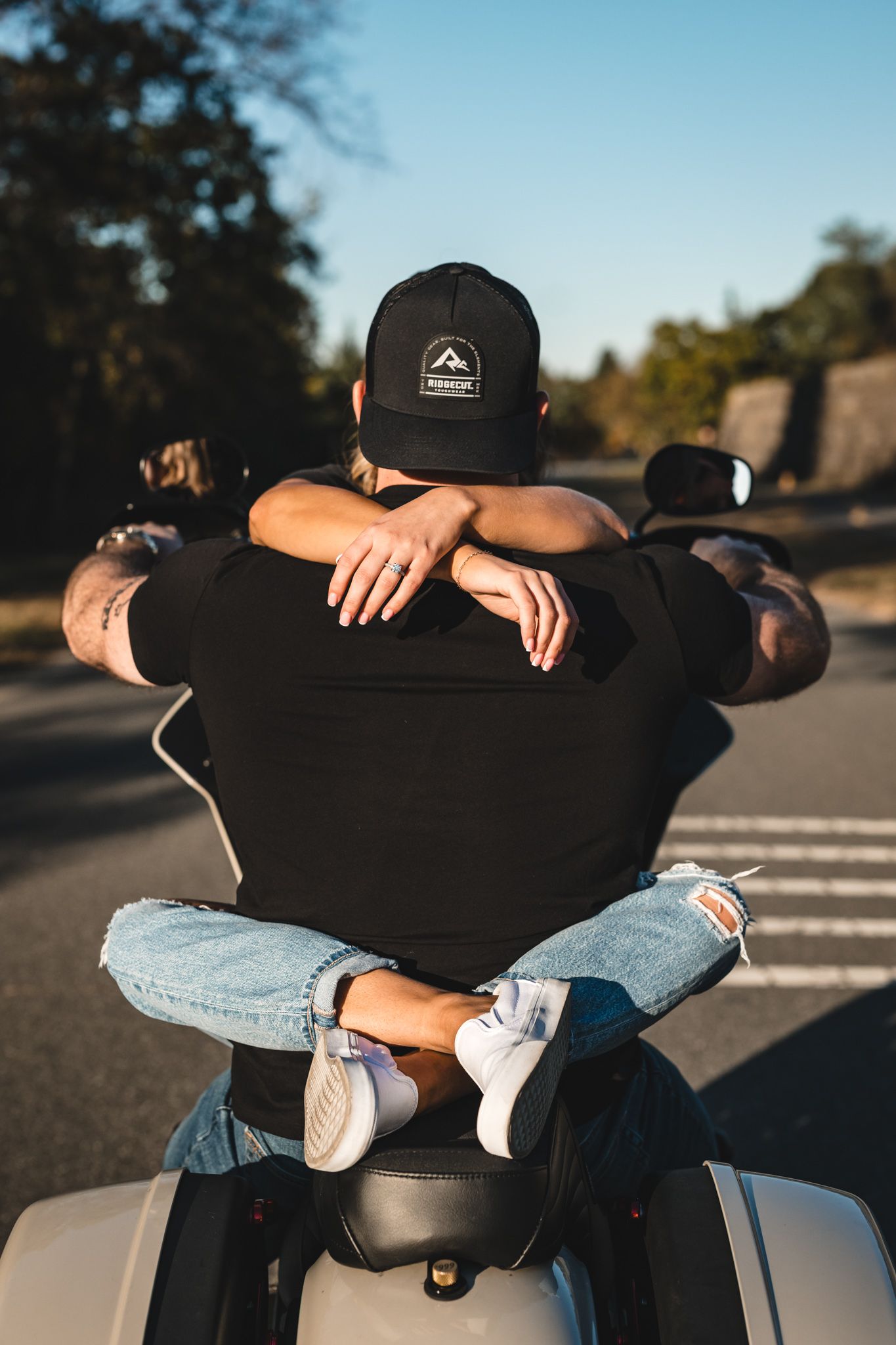 Close-up details of motorcycle riders in casual denim and black attire.