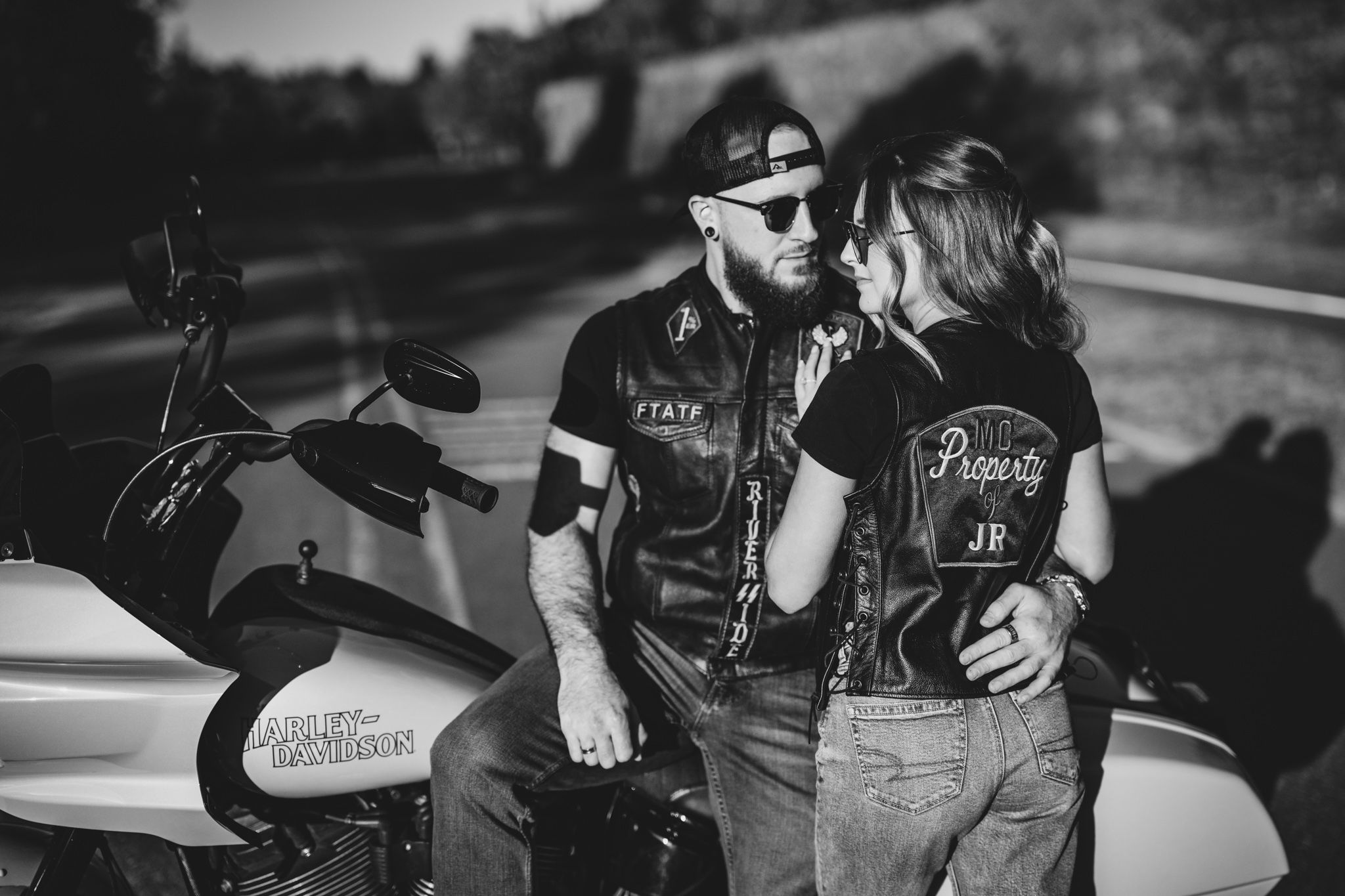 Black and white portrait of couple sharing intimate moment outdoors.