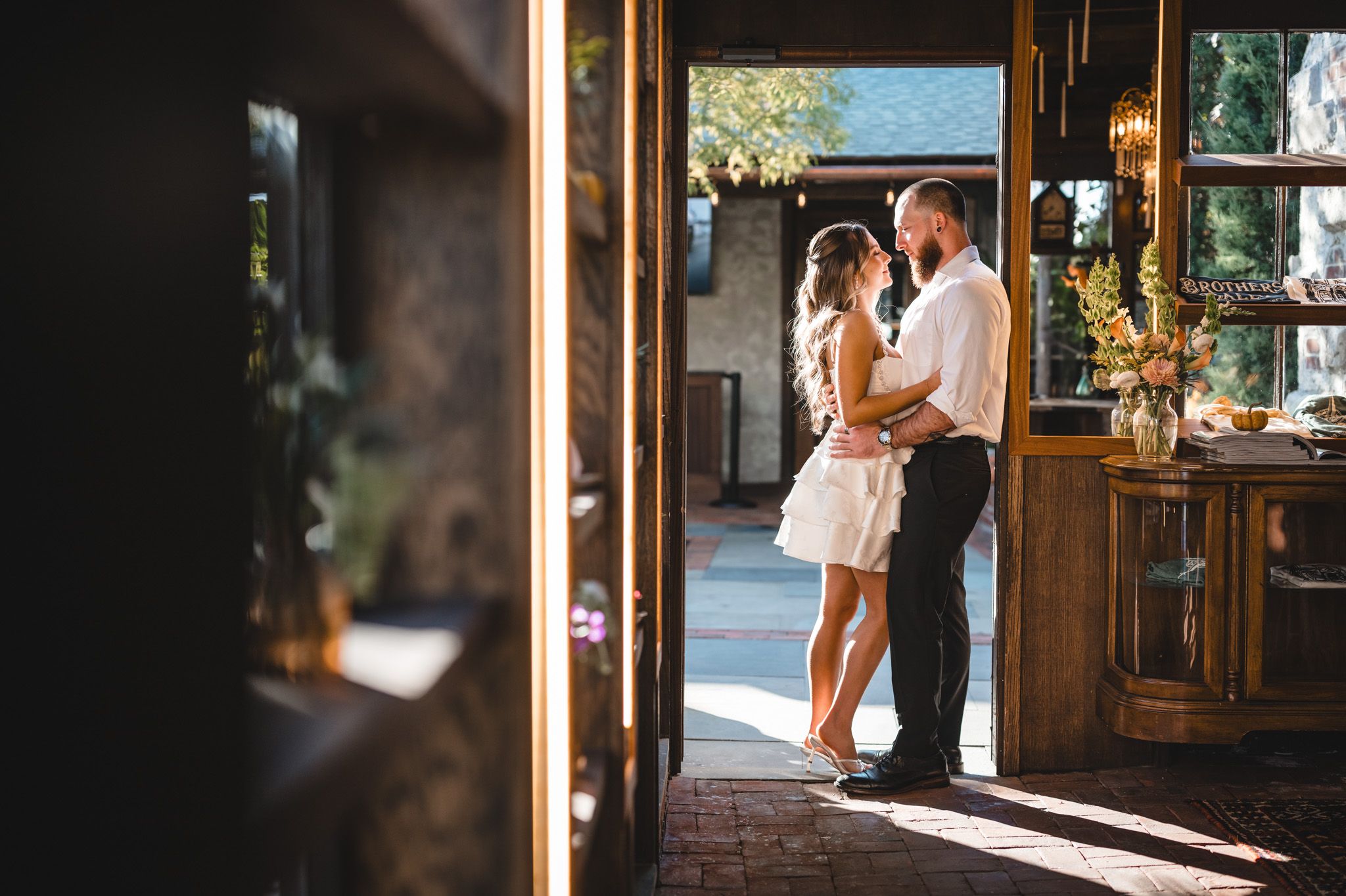 Silhouetted figures in doorway of rustic bar entrance.