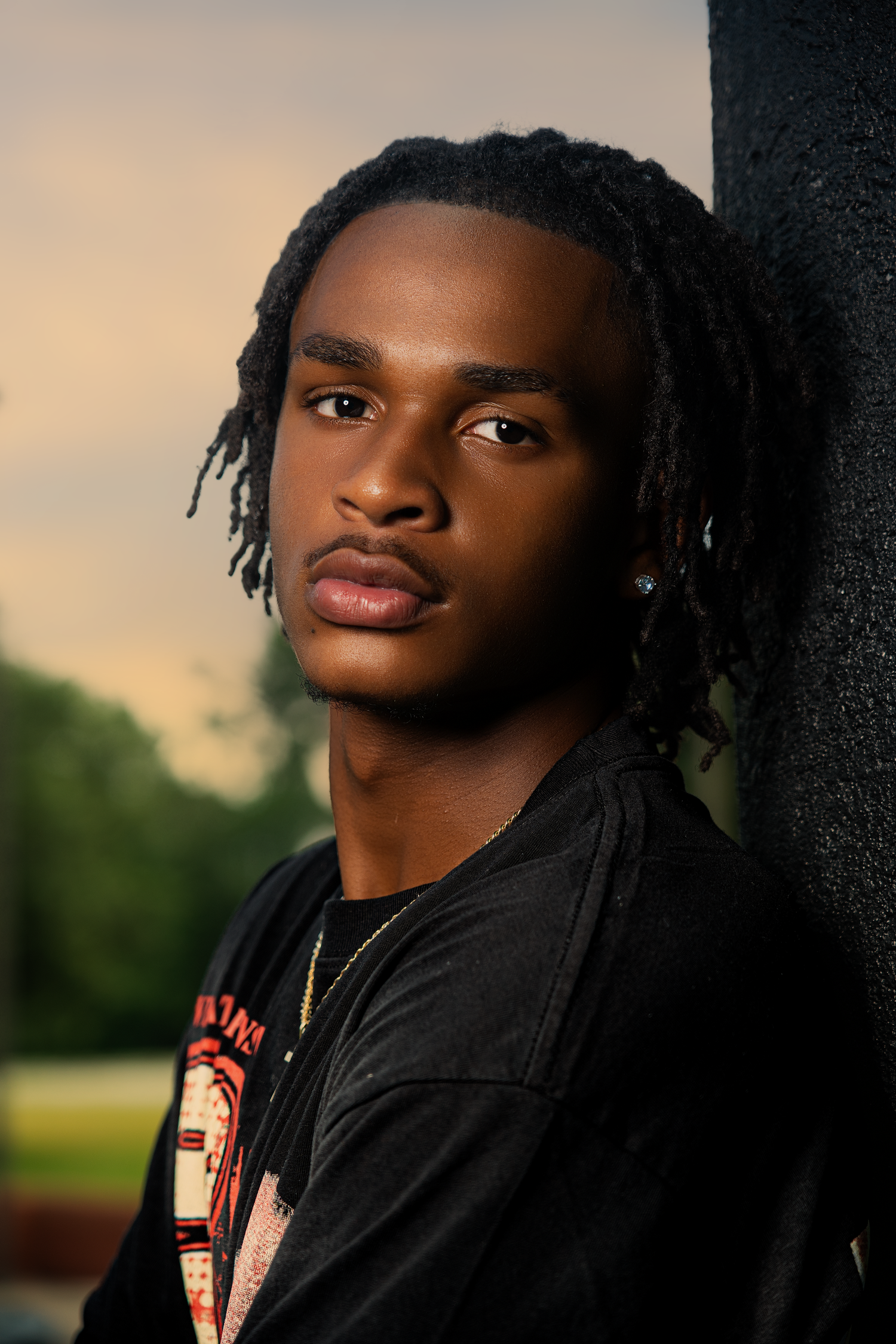 Low angle shots of person wearing ripped jeans and white sneakers against dark background with dramatic lighting.