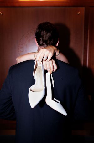 A close-up silhouette shows an intimate embrace between a couple in formal attire.