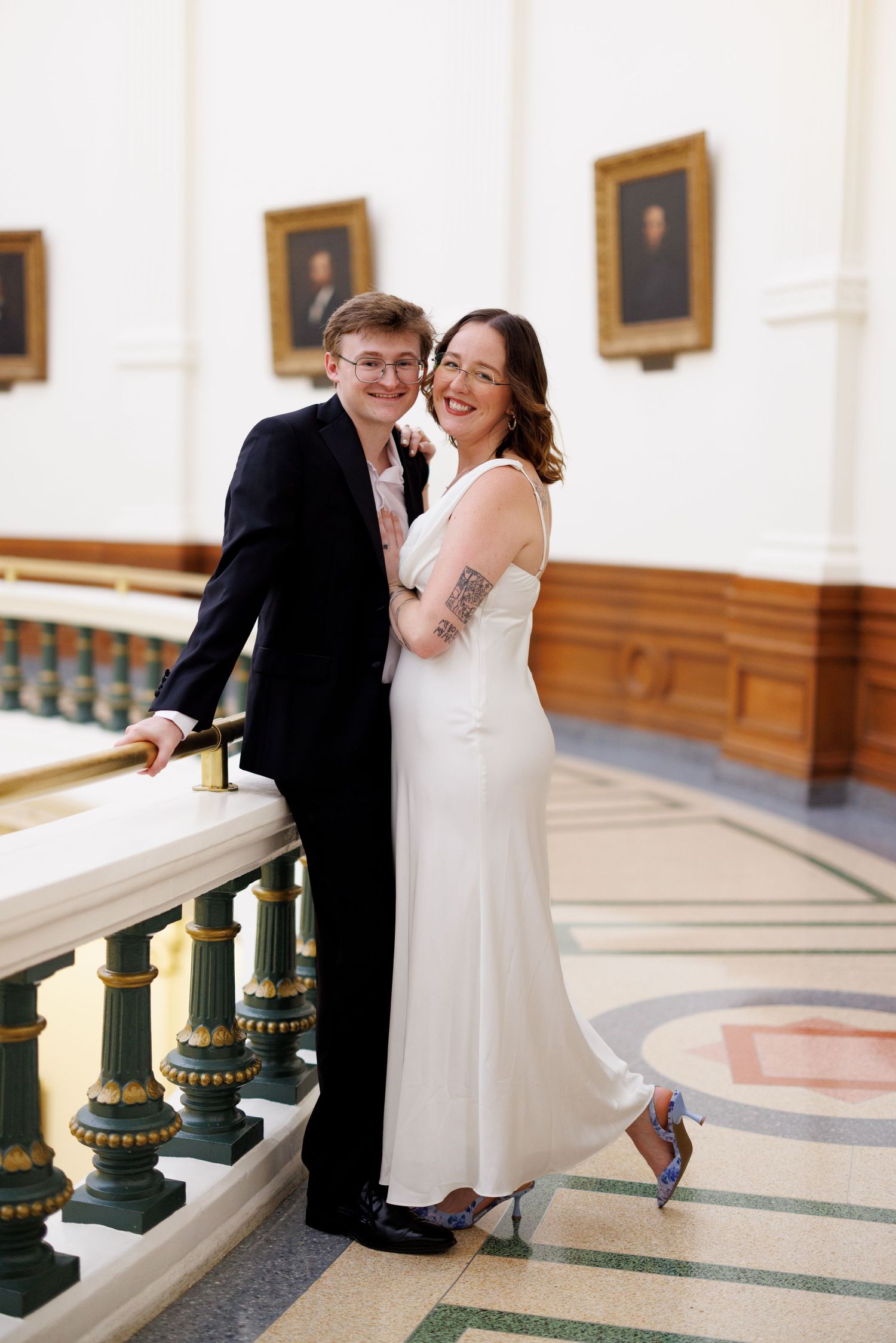 Indoor portrait series along ornate balcony with portrait gallery.