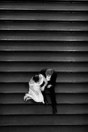 A dramatic black and white photo series shows a couple reclining on dark stairs.