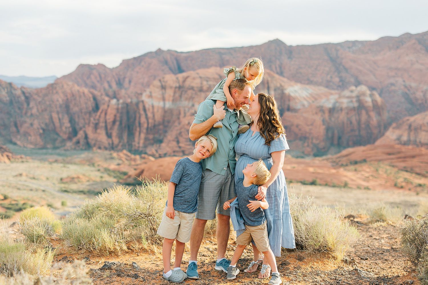 Candid family moments captured against stunning desert canyon backdrop during sunset.
