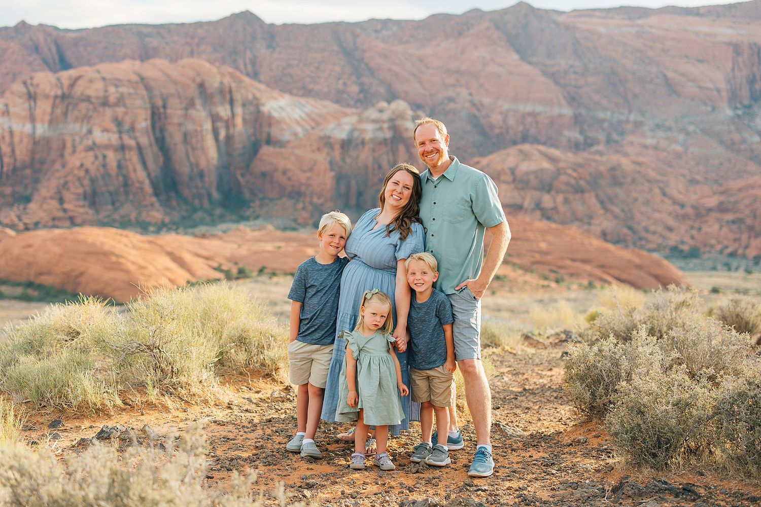 Natural family portraits with scenic desert canyon views during sunset.