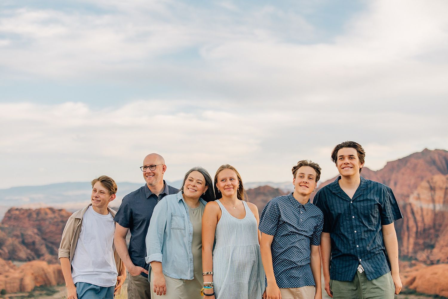Family gathering with scenic desert mountain backdrop during golden hour in Snow Canyon.