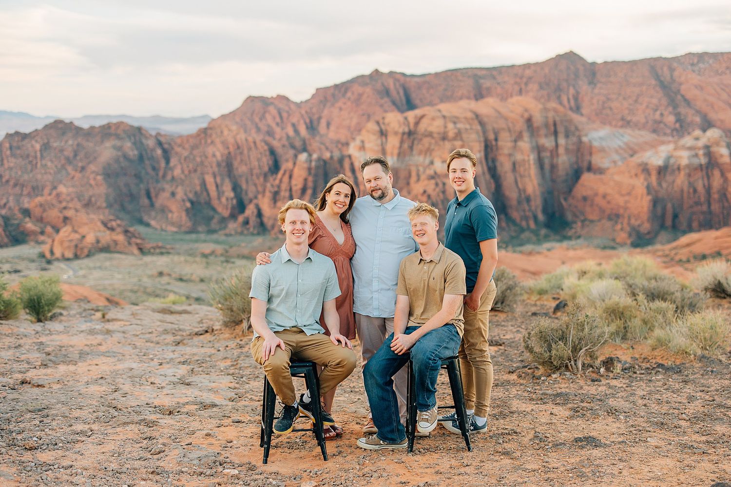 Group portrait session against stunning red rock cliffs and desert landscape in Southern Utah.