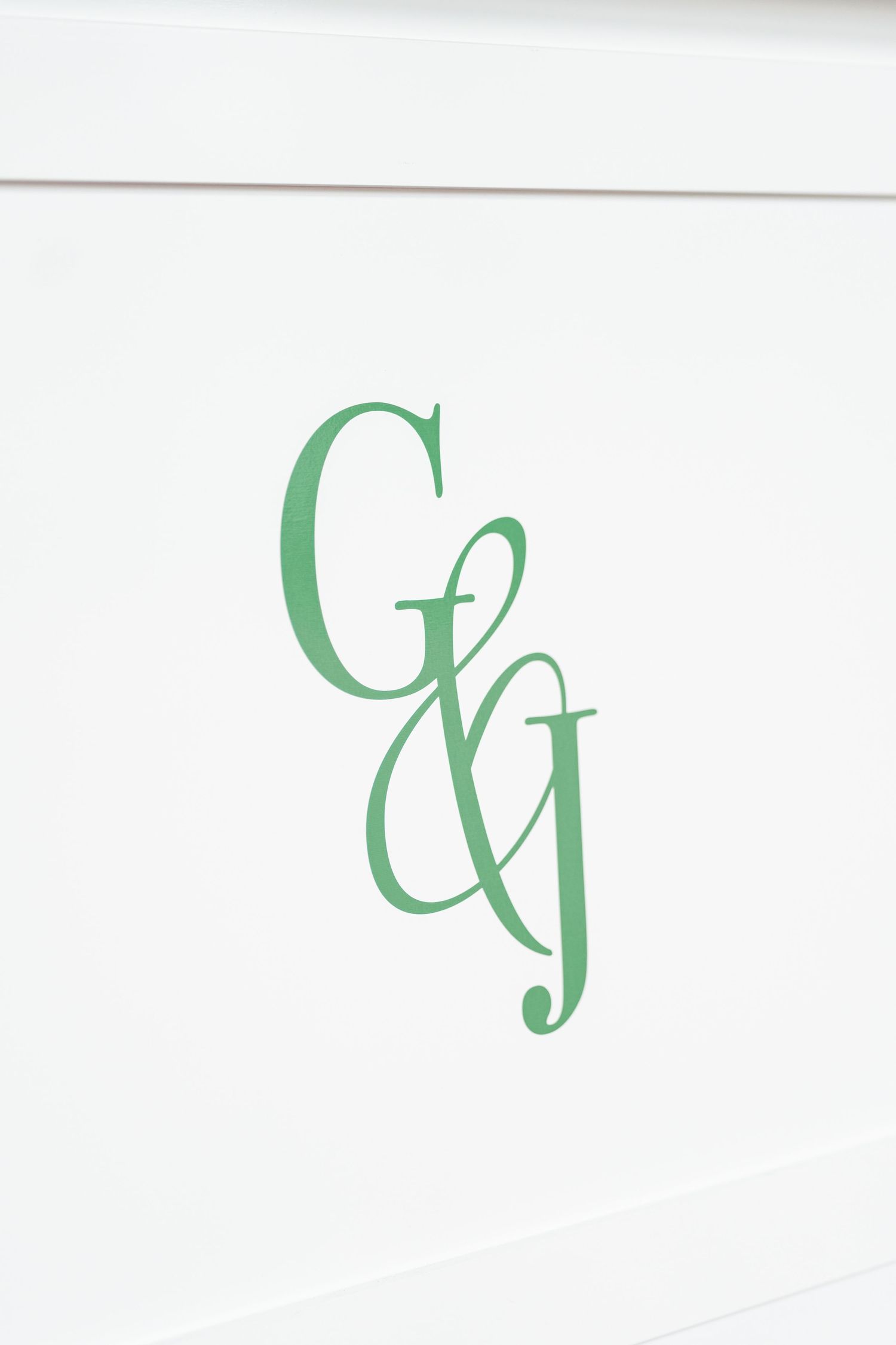 Green intertwined monogram letters G and G in elegant cursive script on white background.