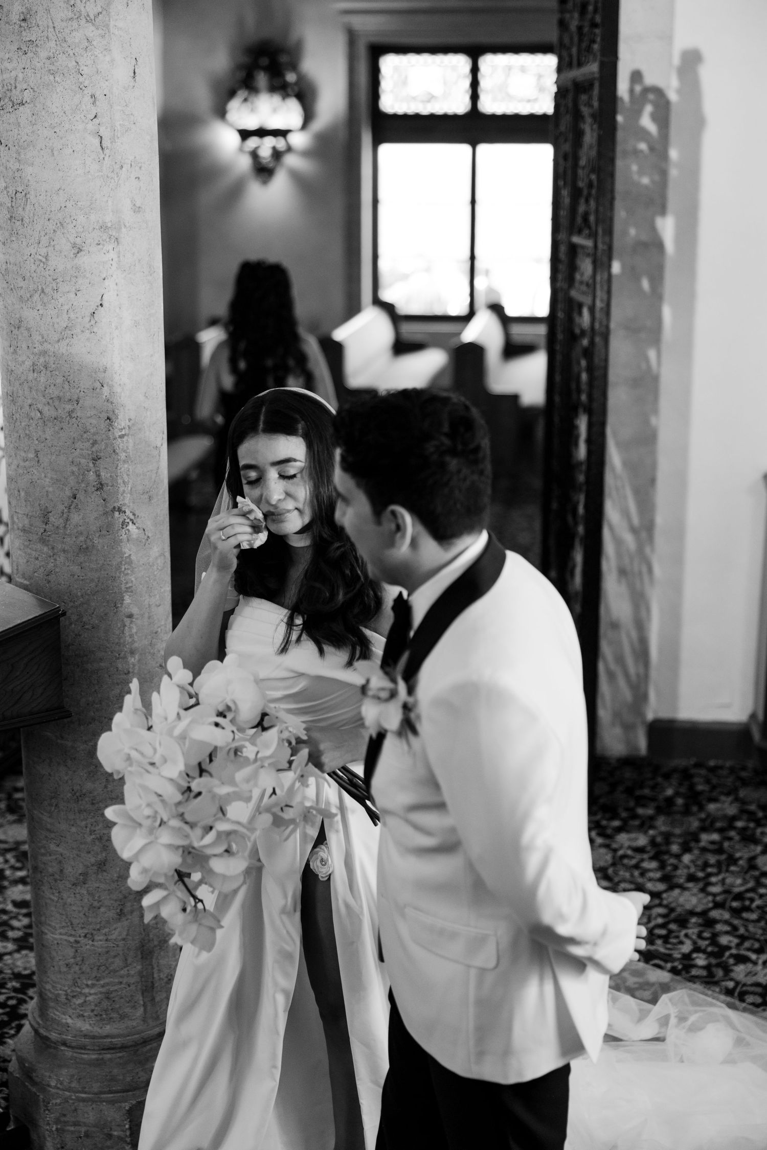A romantic black and white photo series showing tender moments between a couple on their wedding day.