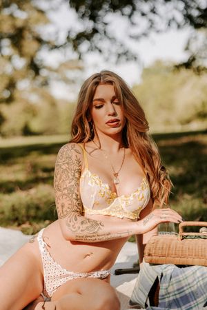 Summer picnic boudoir session featuring delicate lingerie and warm golden hour lighting.