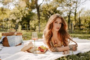 Outdoor portrait session with rustic picnic setup and warm afternoon light.