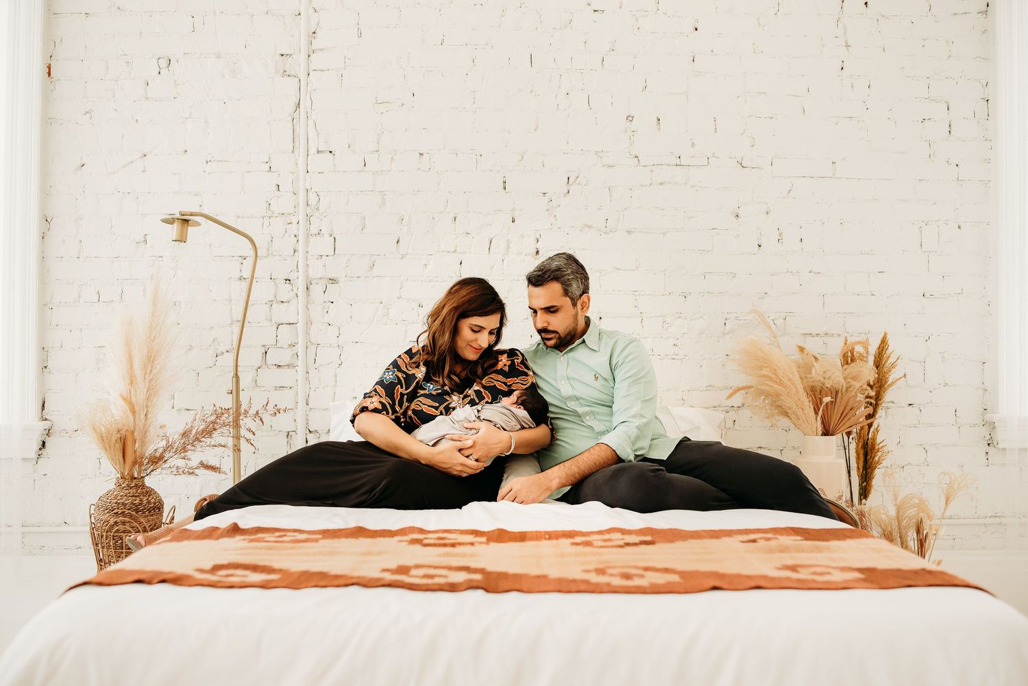 Mom holding newborn baby during a cozy studio session in Cincinnati.