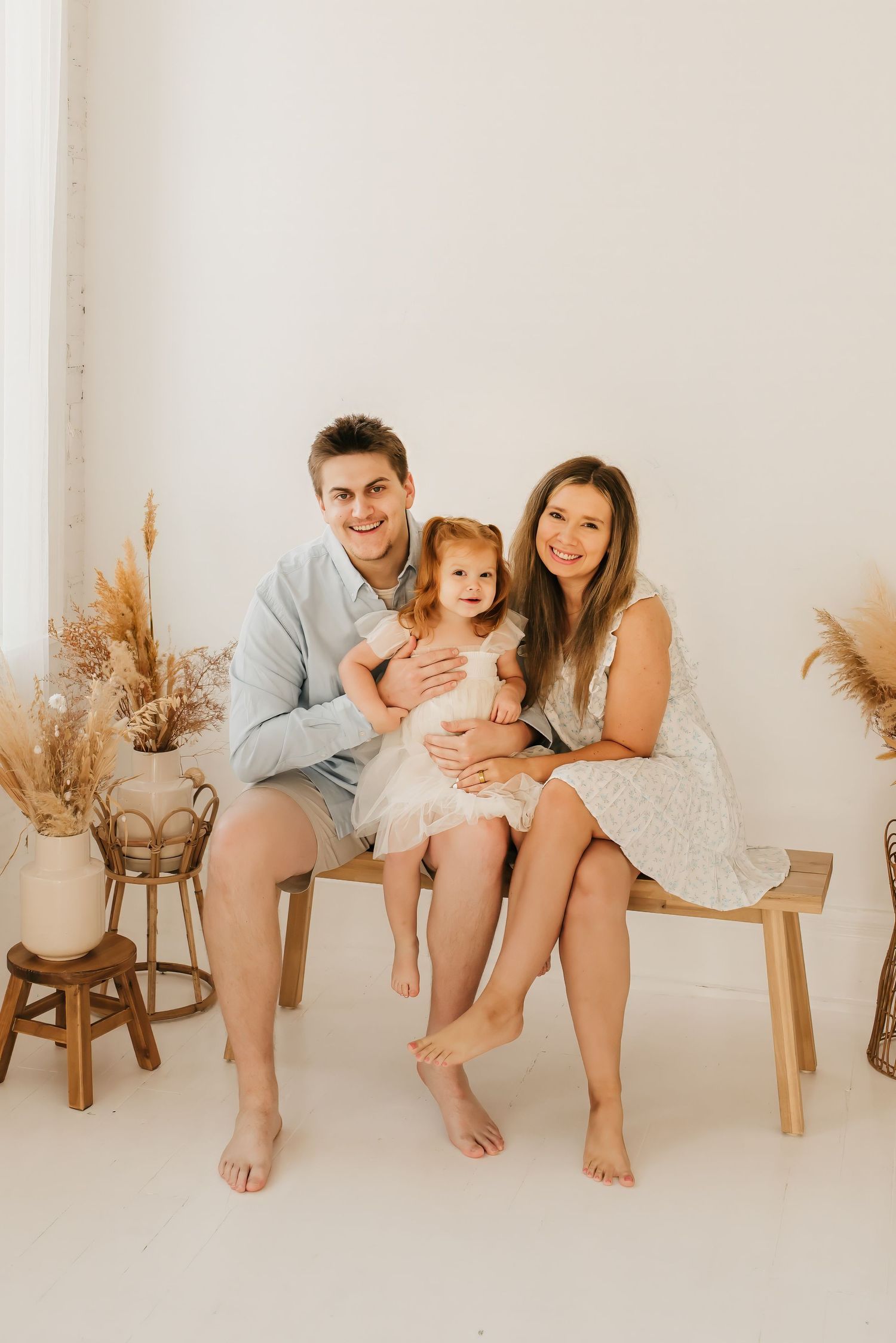 Lifestyle family portrait in a bright Cincinnati photography studio with natural light and neutral décor.