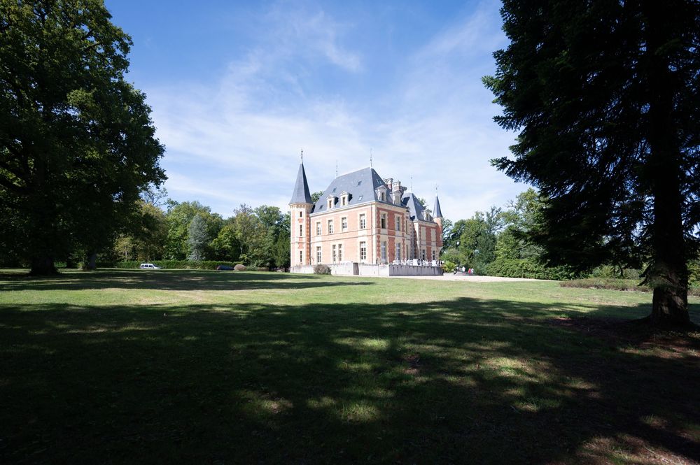 Photographe professionnelle de mariage à Blois immortalisant le château du lieu de réception sous un ciel bleu.