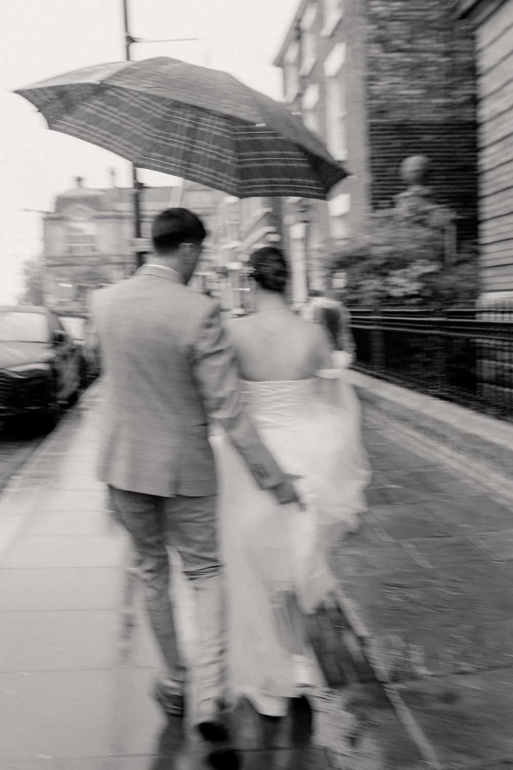 A sequence of black and white photos showing a couple walking with umbrellas on a rainy street.