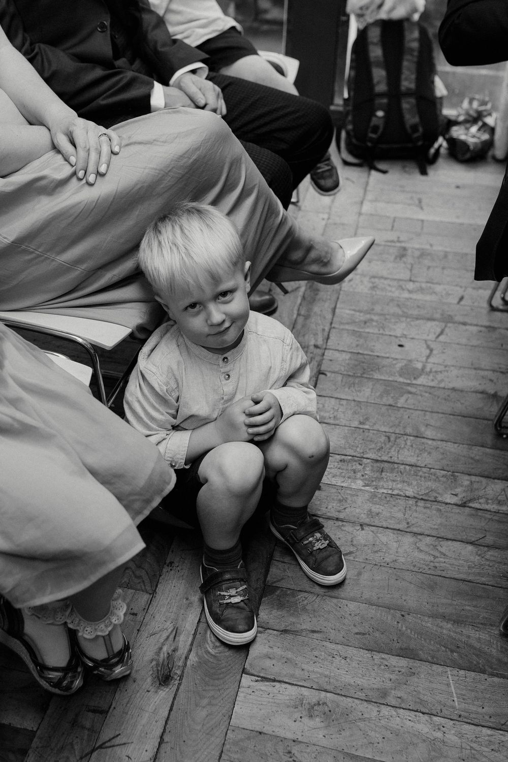 Black and white sequence of a small child crawling across a wooden floor.