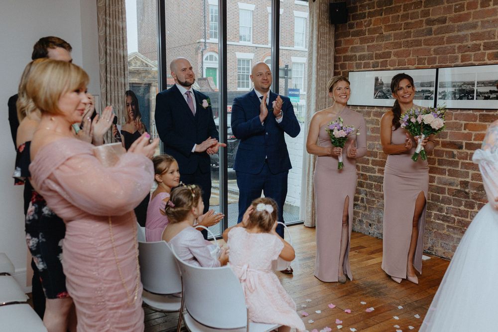 A series of wedding reception photos showing guests mingling and celebrating in a rustic brick-walled venue.