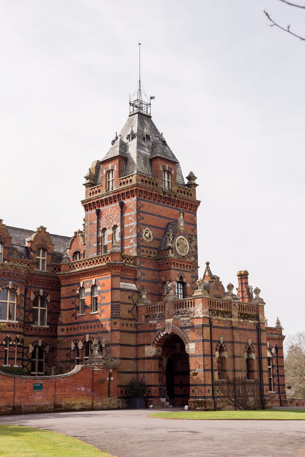 Historic red brick Victorian clock tower and entrance gate with ornate architectural details at The Elvetham in Hampshire