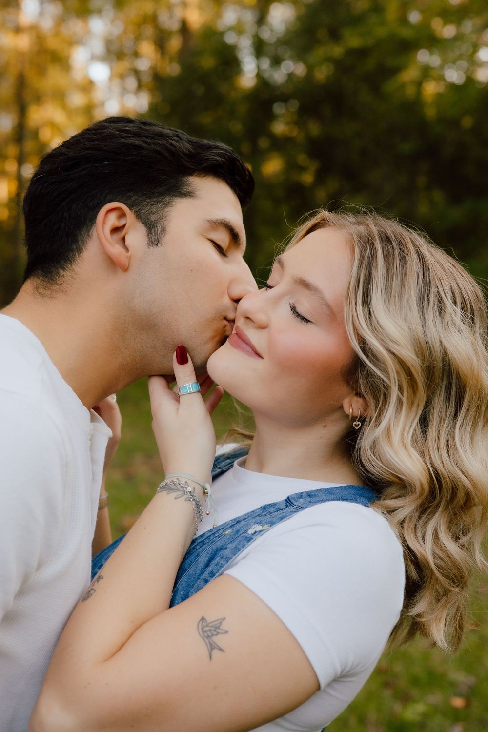 A romantic couple sharing tender kisses in a series of intimate outdoor photos with golden sunlight in the background.