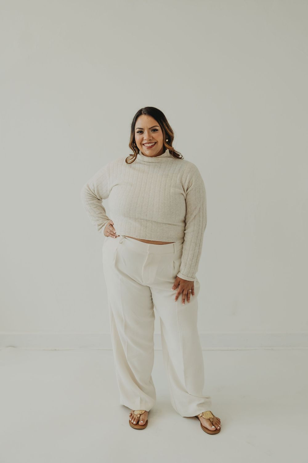 Stylish cream-colored loungewear set featuring a cropped turtleneck sweater and wide-leg pants paired with sandals.
