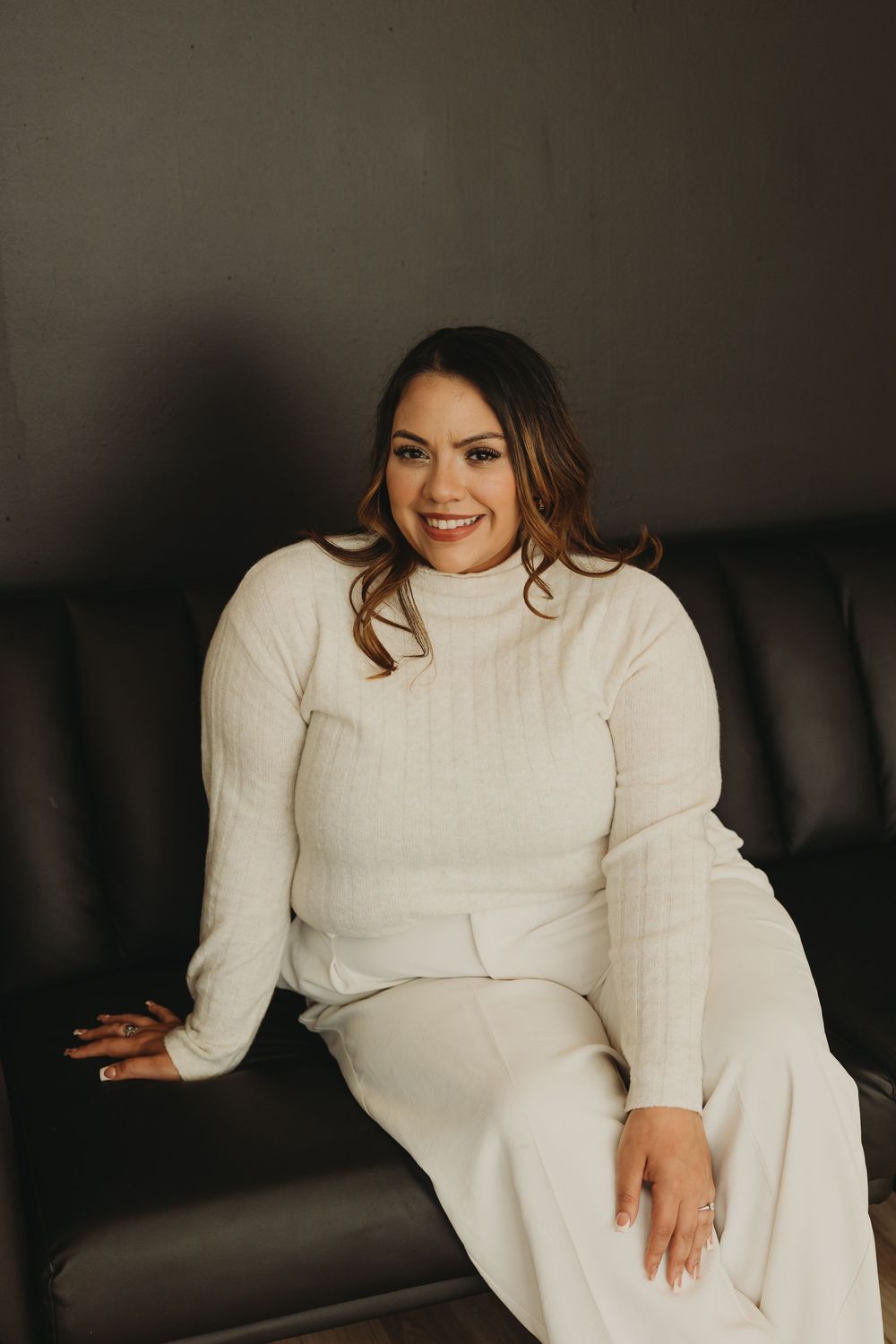A series of lifestyle portraits showing someone in a cozy white sweater lounging on dark furniture.