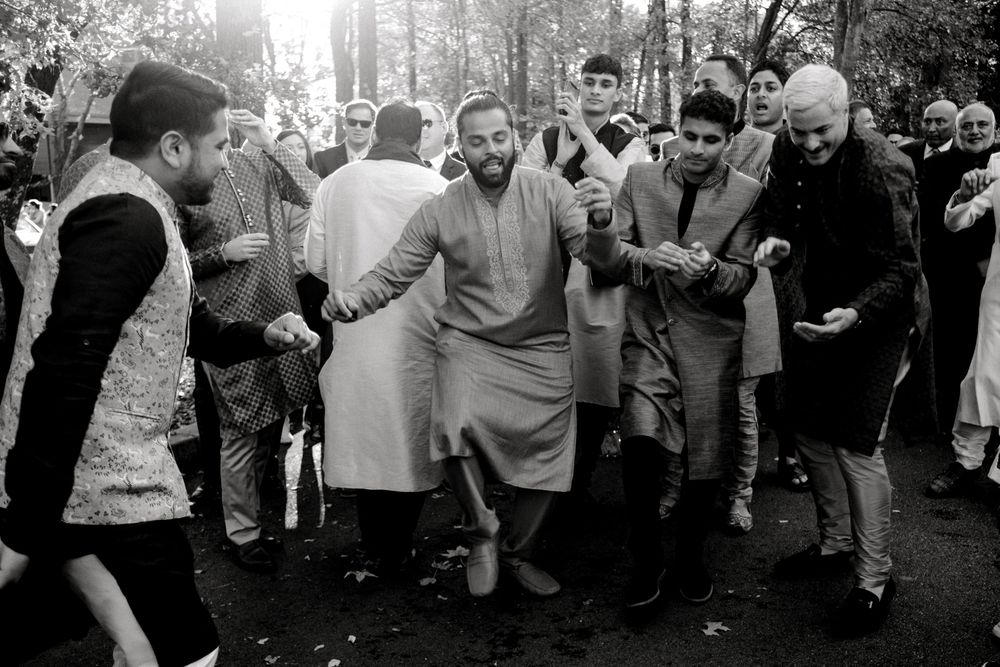 A black and white photograph shows people dancing together in a casual outdoor gathering in what appears to be a park.