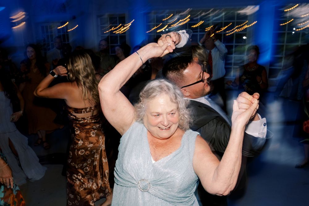Energetic dancers enjoying themselves on a dance floor with blue lighting and motion blur effects in the background.
