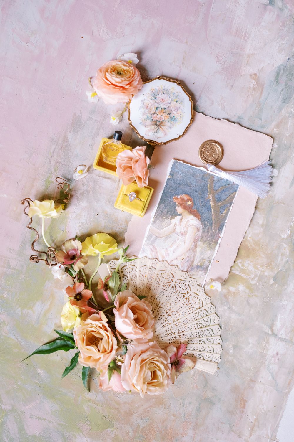 Vintage-inspired flat lay composition with delicate lace doilies, pastel flowers, and decorative elements on a textured surface.