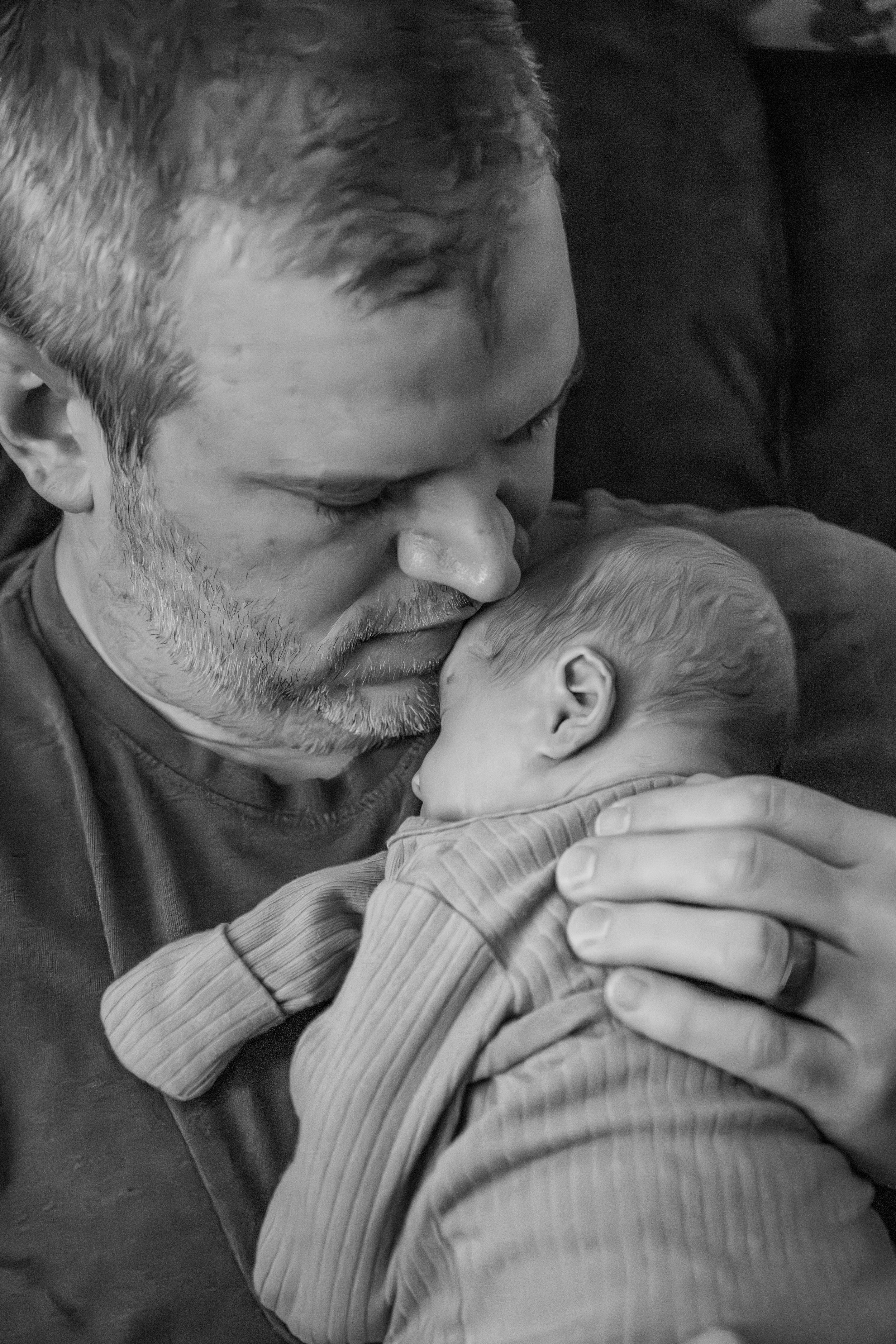 A dad kissing his baby.