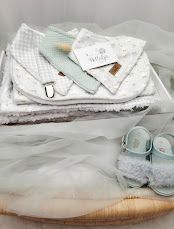 Soft baby gift set with mint shoes, checkered bib, pacifier clip, and white blankets in a delicate box.