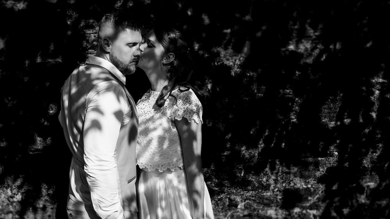 Black and white close-up of a bride holding a lush white floral bouquet on her wedding day.