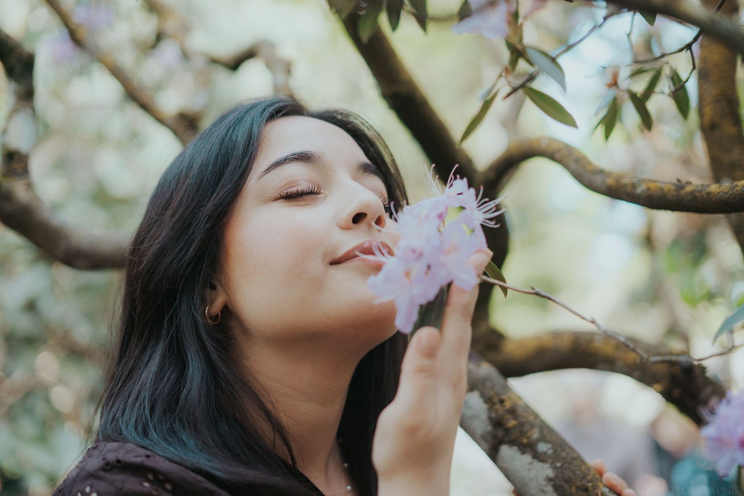 Portrait de femme sentant une fleur au jardin botanique