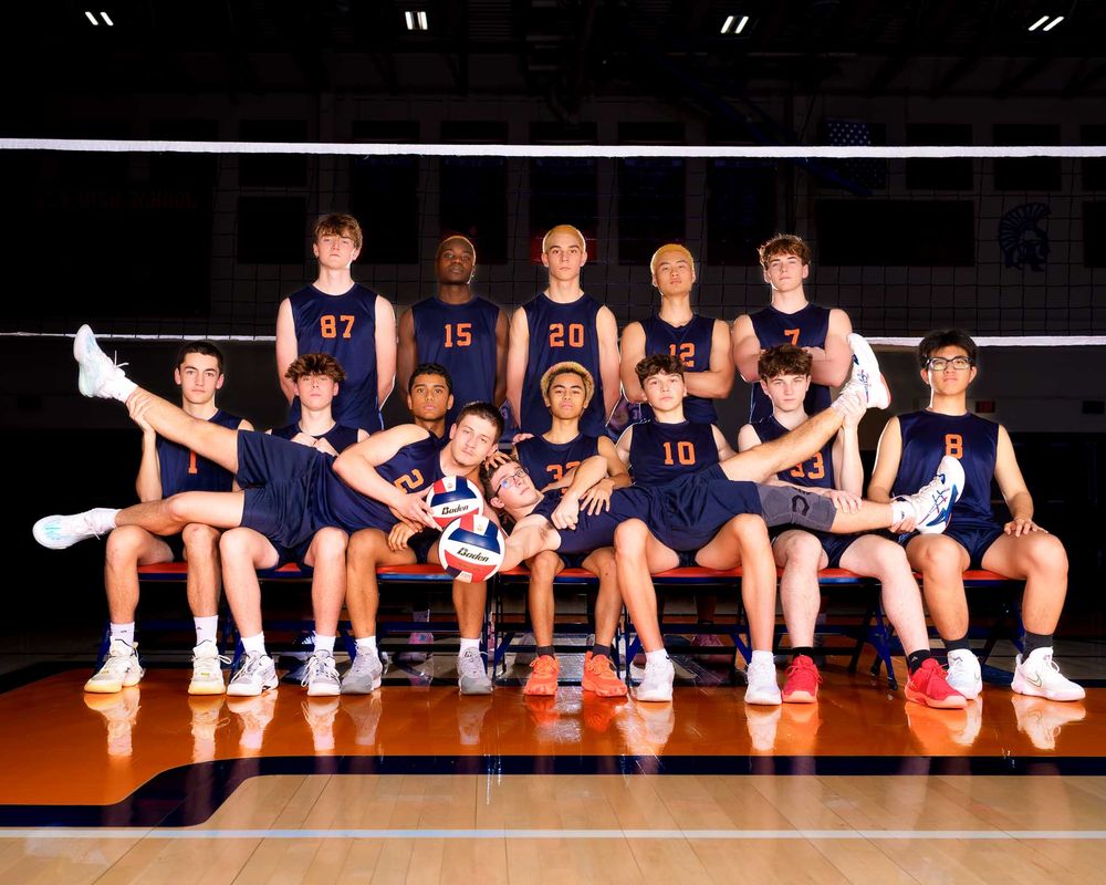 Hershey varsity volleyball team poses in navy uniforms in the gym for media day by Deanna Fox, SportsFox Photography based in Hershey PA.