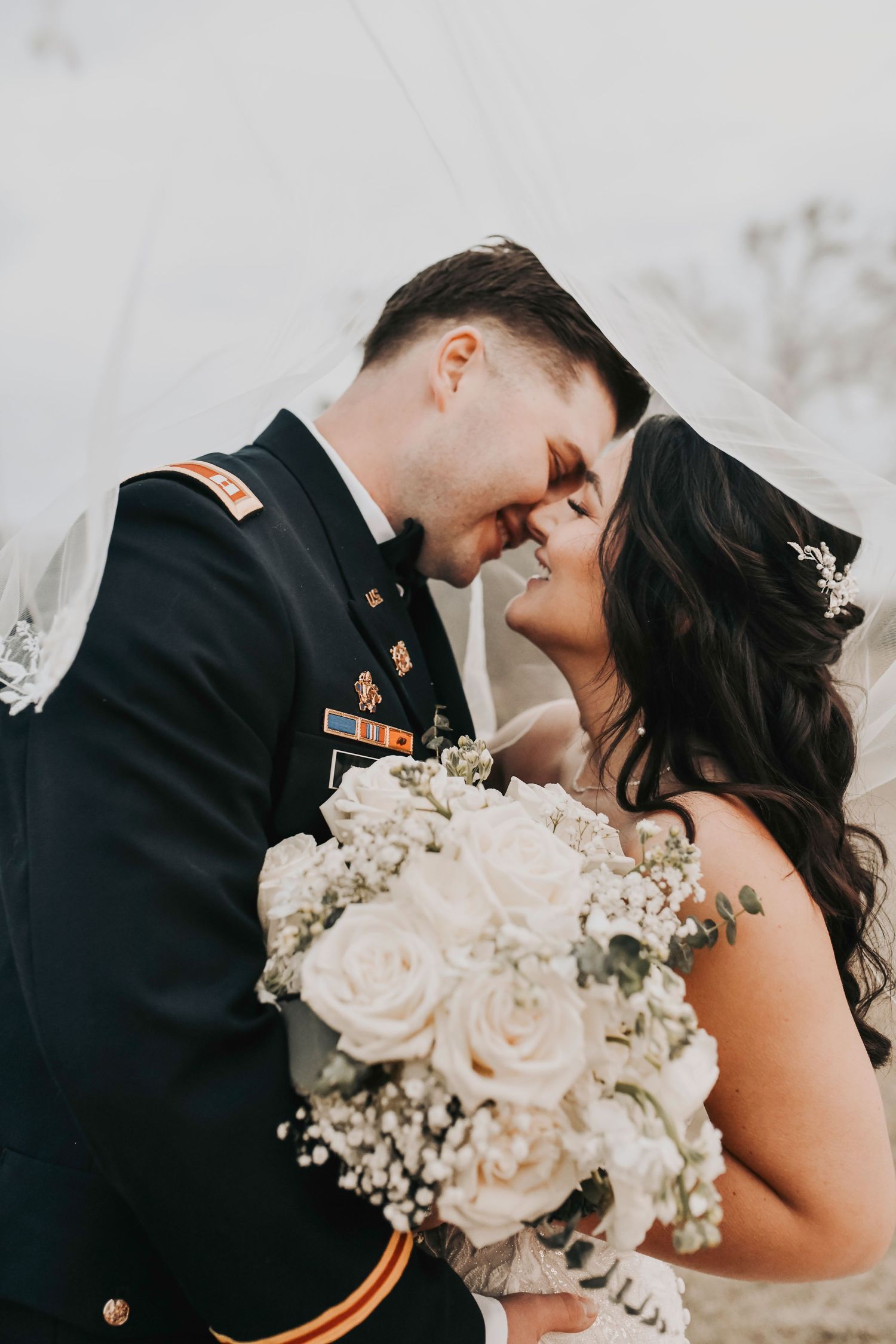 Romantic wide-angle shot of bride and groom on the ranch with natural textures and warm tones.