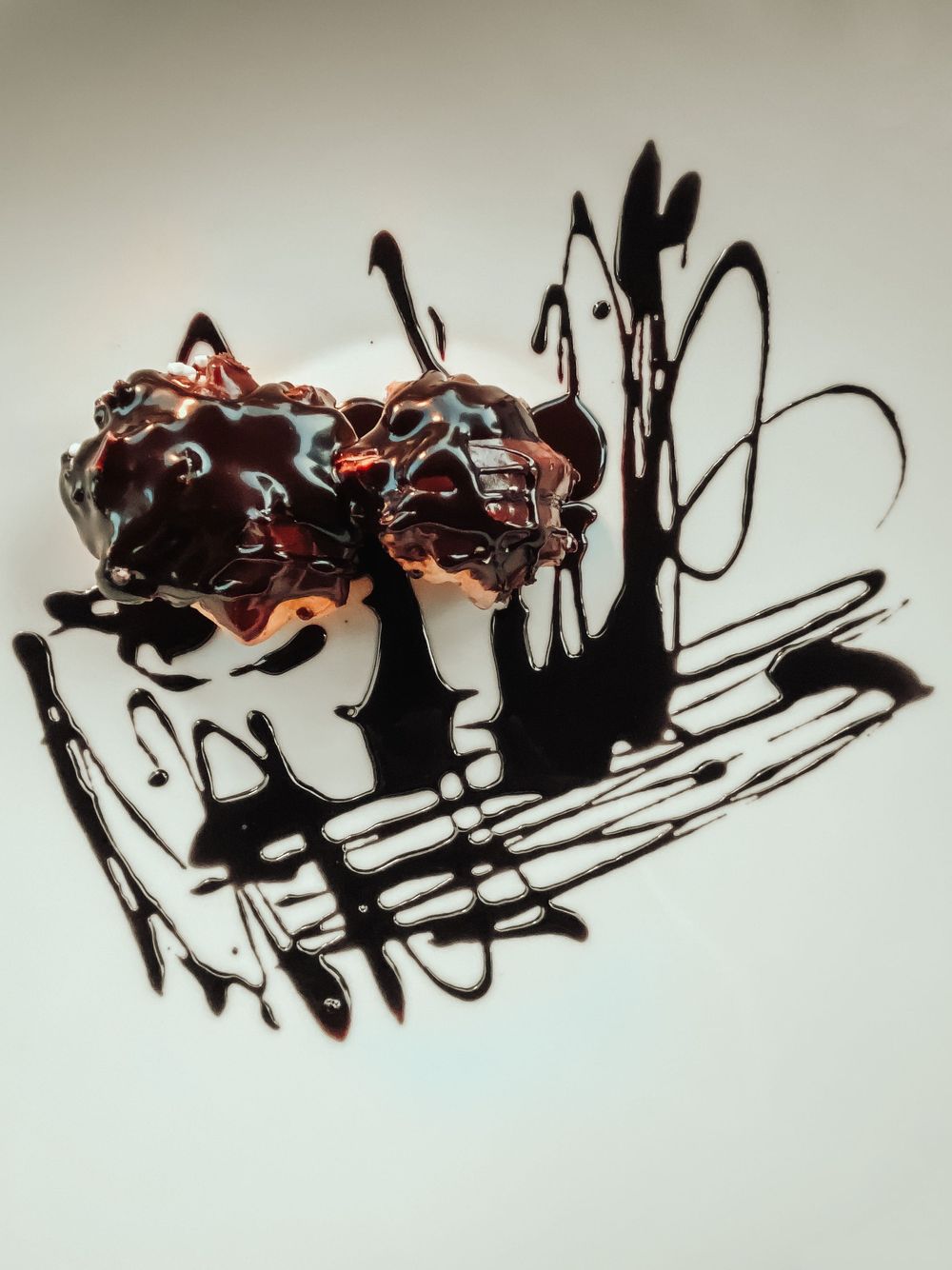 Abstract black ink splatters and brushstrokes form dynamic patterns against a light background in a series of artistic images.