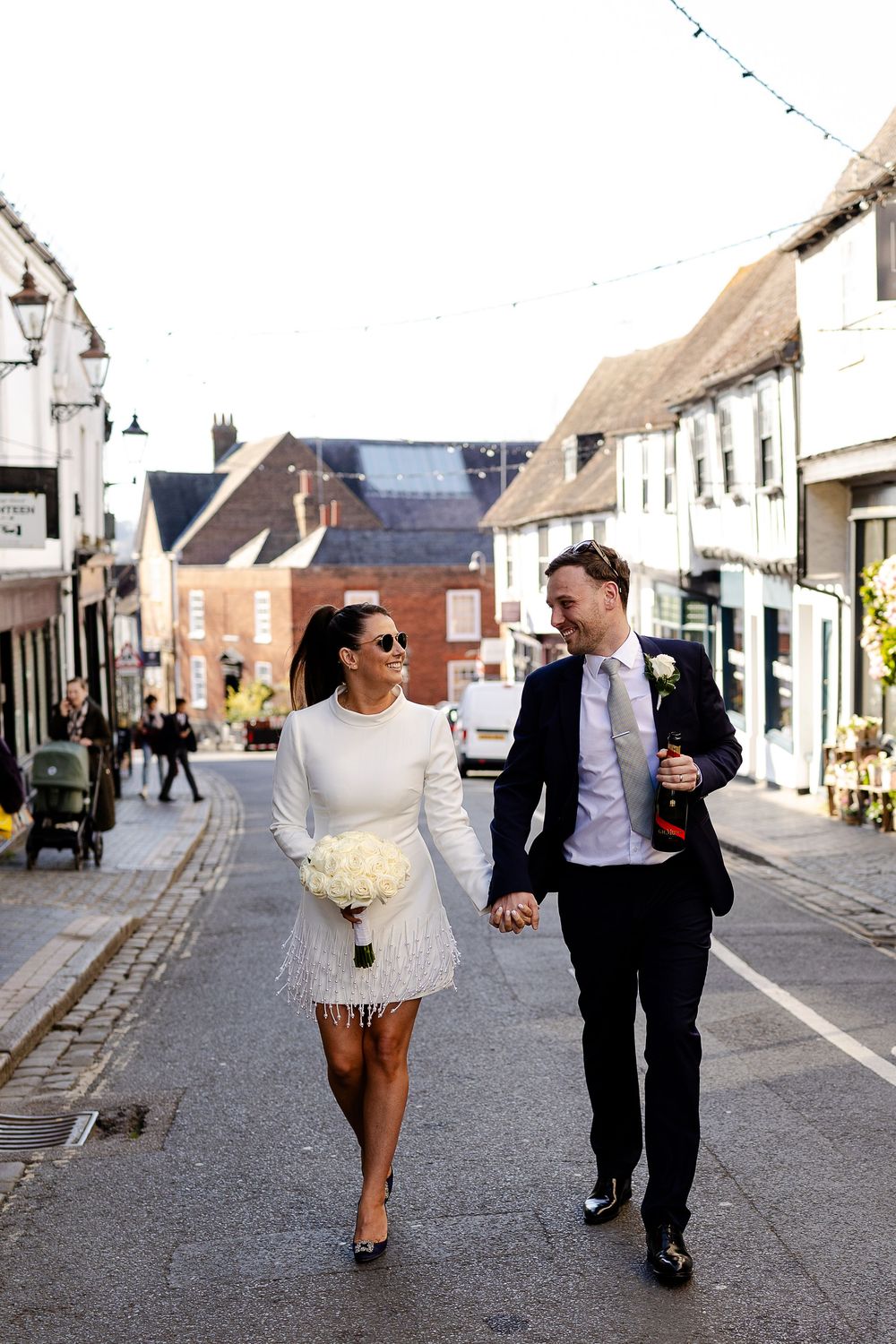 Couple walking together down a charming cobblestone village street.