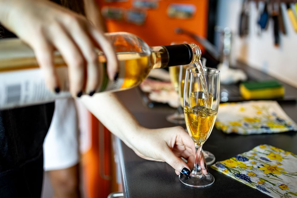 Wedding preparations with champagne glasses and beauty treatments in a sunlit room.