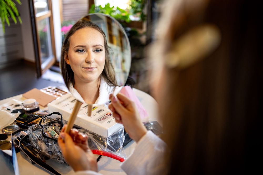 Getting ready scene with makeup brushes and wedding preparations.