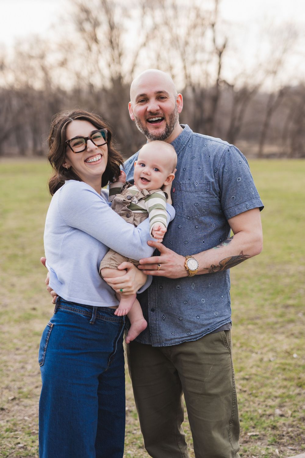 A loving family shares playful moments together while taking photos outdoors in casual attire.