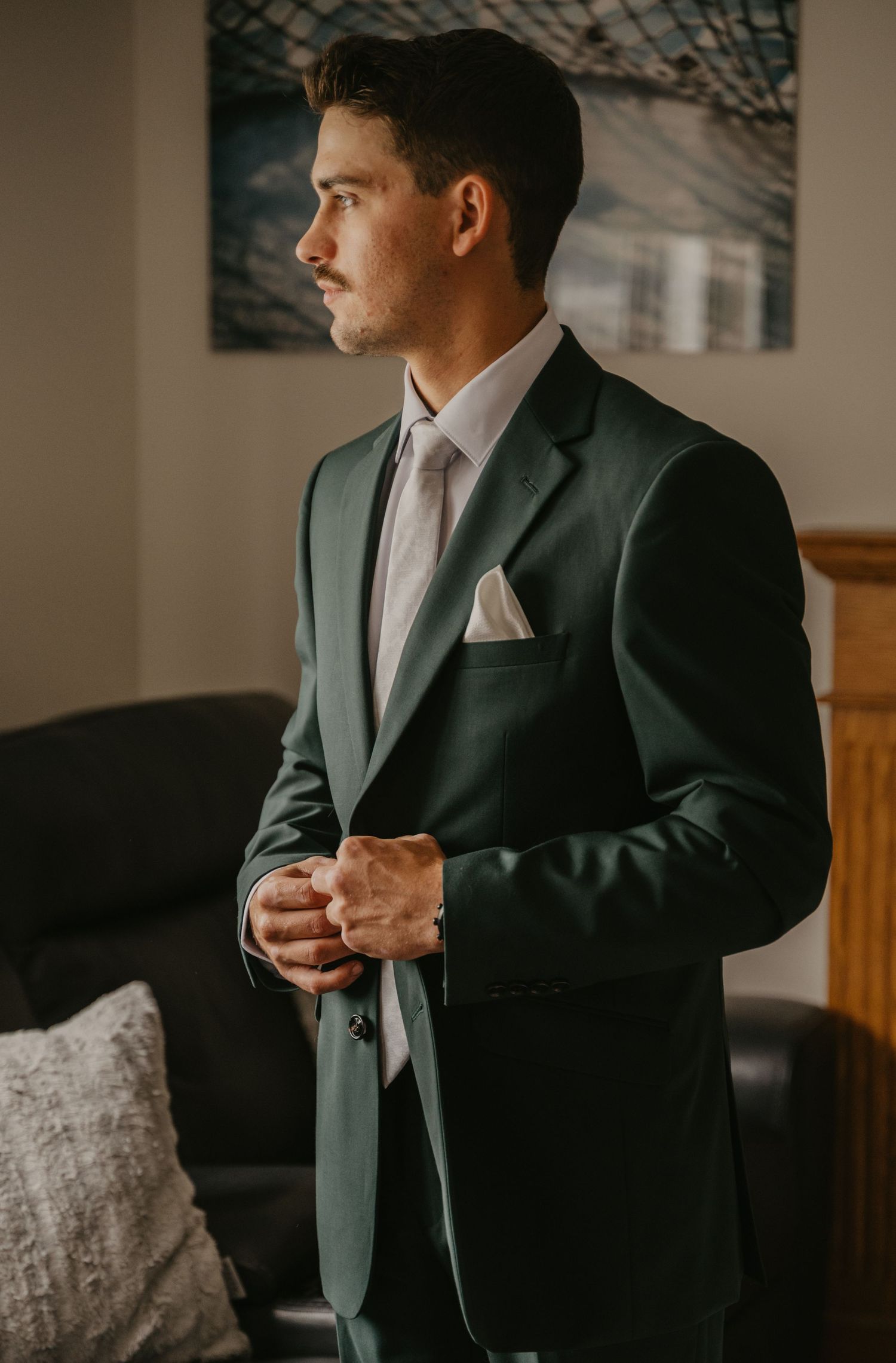 Person in dark suit jacket and tie making final adjustments before ceremony.