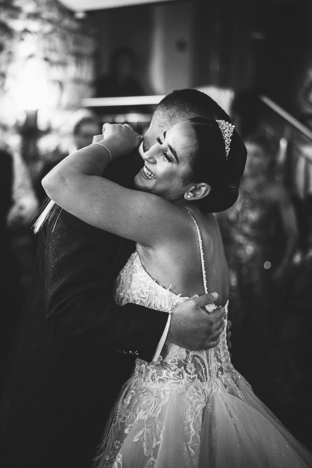 A bride in a lace wedding gown dances gracefully in black and white photography.