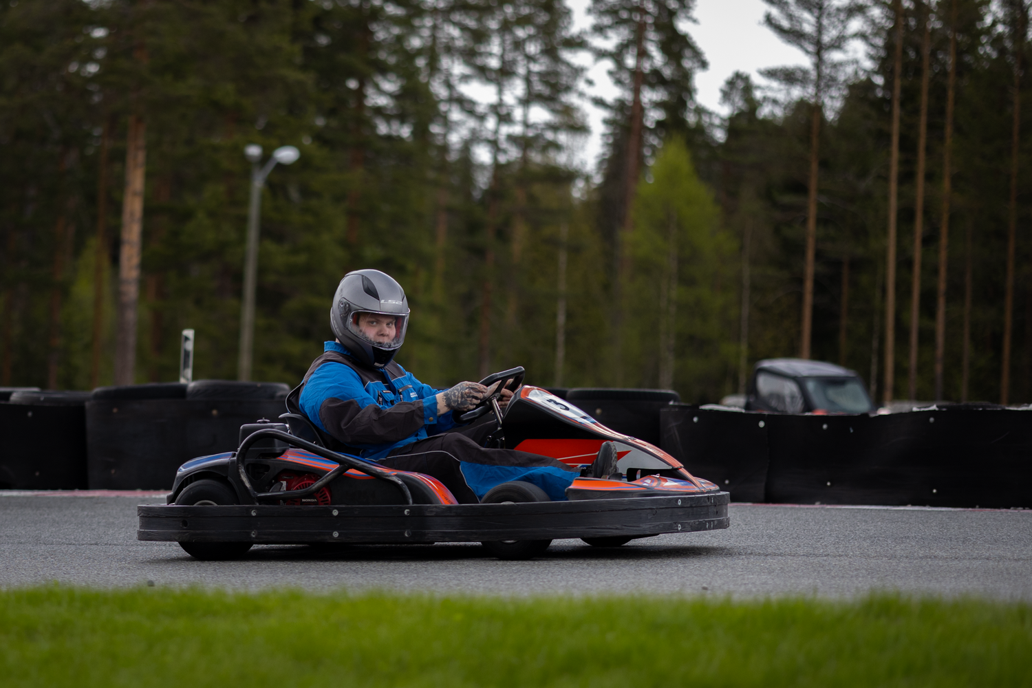 Gokart-sjåfør i aksjon på bane, fotografert av Prospectxmedia. Bedriftsfoto og eventfoto i Norge.