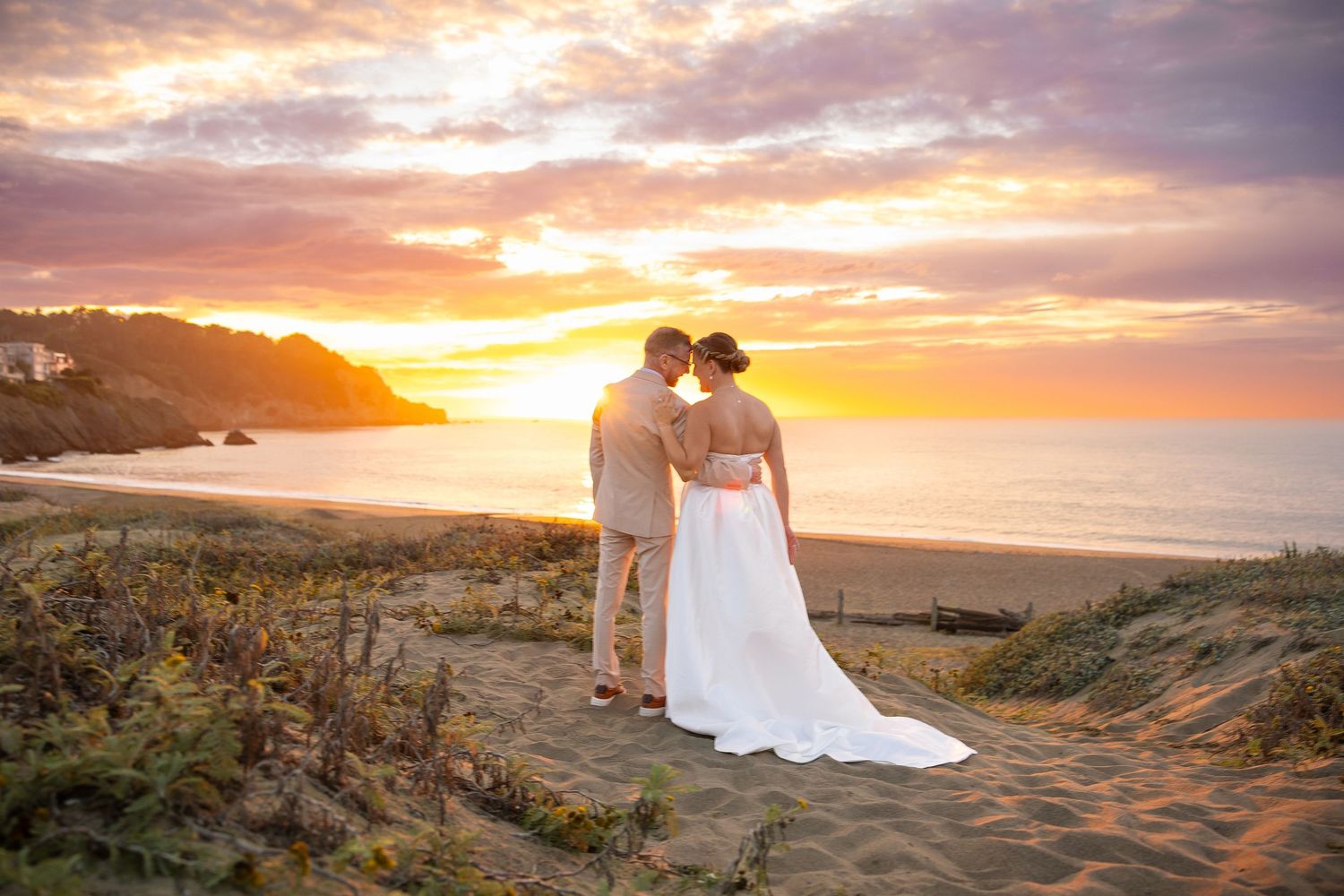 Stunning beach wedding photos captured during golden hour sunset with dramatic coastal views.